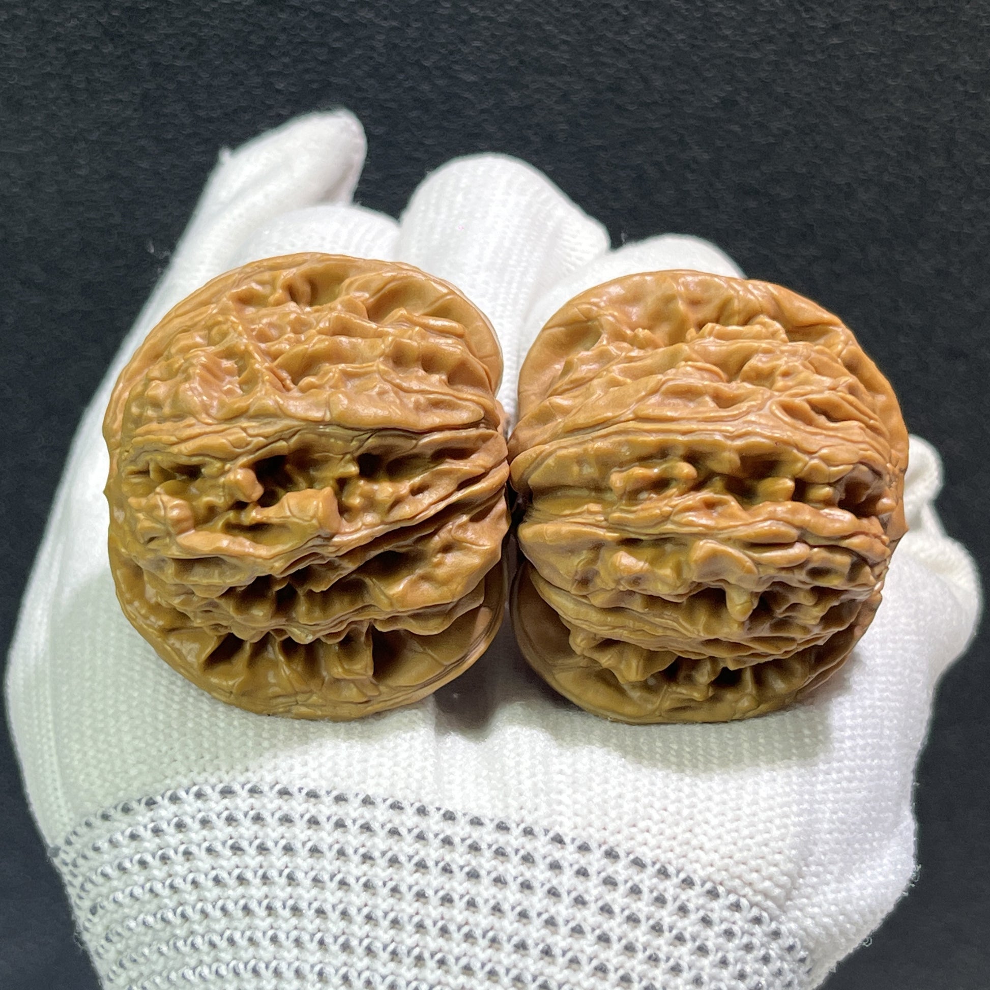 Pair of walnut lion's head hand exercisers from ThePatinaProject, 42mm x 41mm, showcasing detailed carved lion heads.