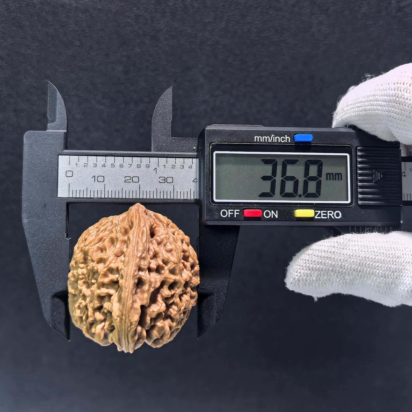 Walnut hand exerciser pair labeled Triangle Nan Jiang Shi, 39mm x 37mm, from ThePatinaProject, with textured wooden surface.