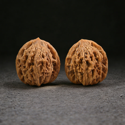 Pair of Walnut Hand Exercisers with wheat ear tiger head design, 35mm size, from ThePatinaProject, showcasing textured natural wood.