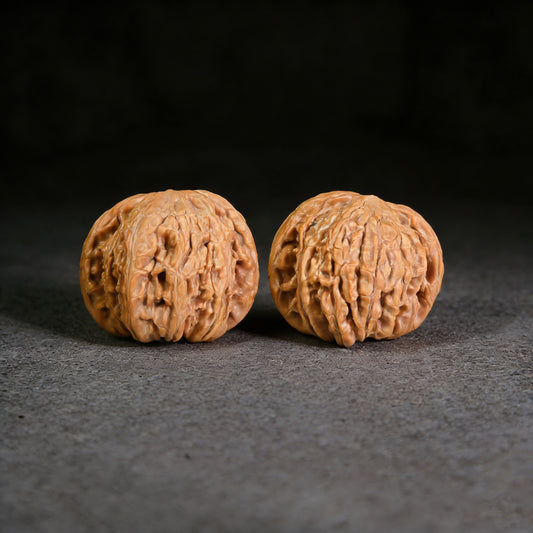 White Lion Walnut Hand Exerciser pair from ThePatinaProject, 39mm x 36mm, showing polished walnut handles and textured grips.