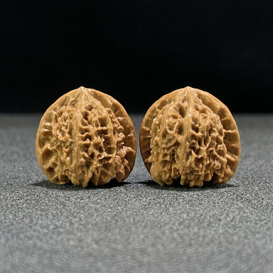 Walnut hand exercisers pair "Wild Bull" (Ye Niu) by ThePatinaProject, 40mm x 37mm, showing textured walnut surface and ergonomic design.