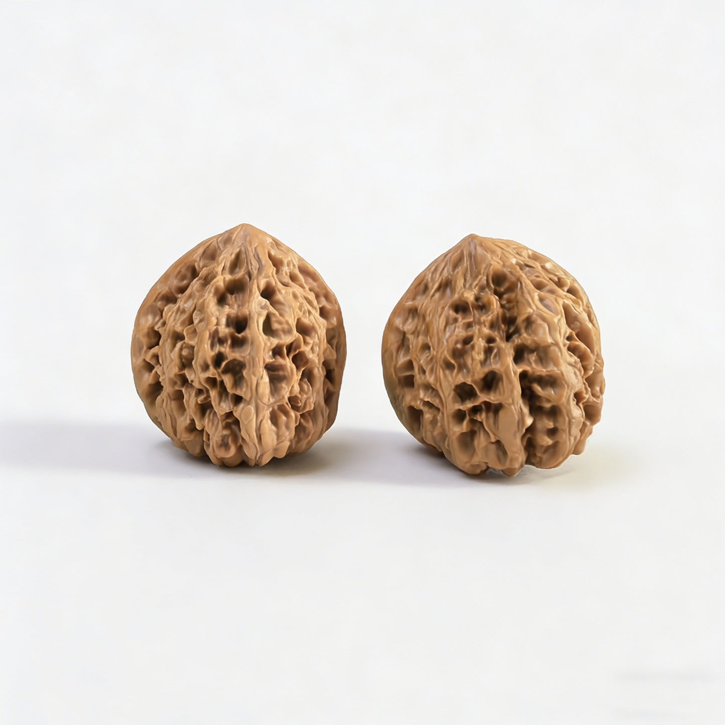 Pair of Wild Bull lion head walnut hand exercisers from ThePatinaProject, 35mm diameter, showing detailed lion head carvings.