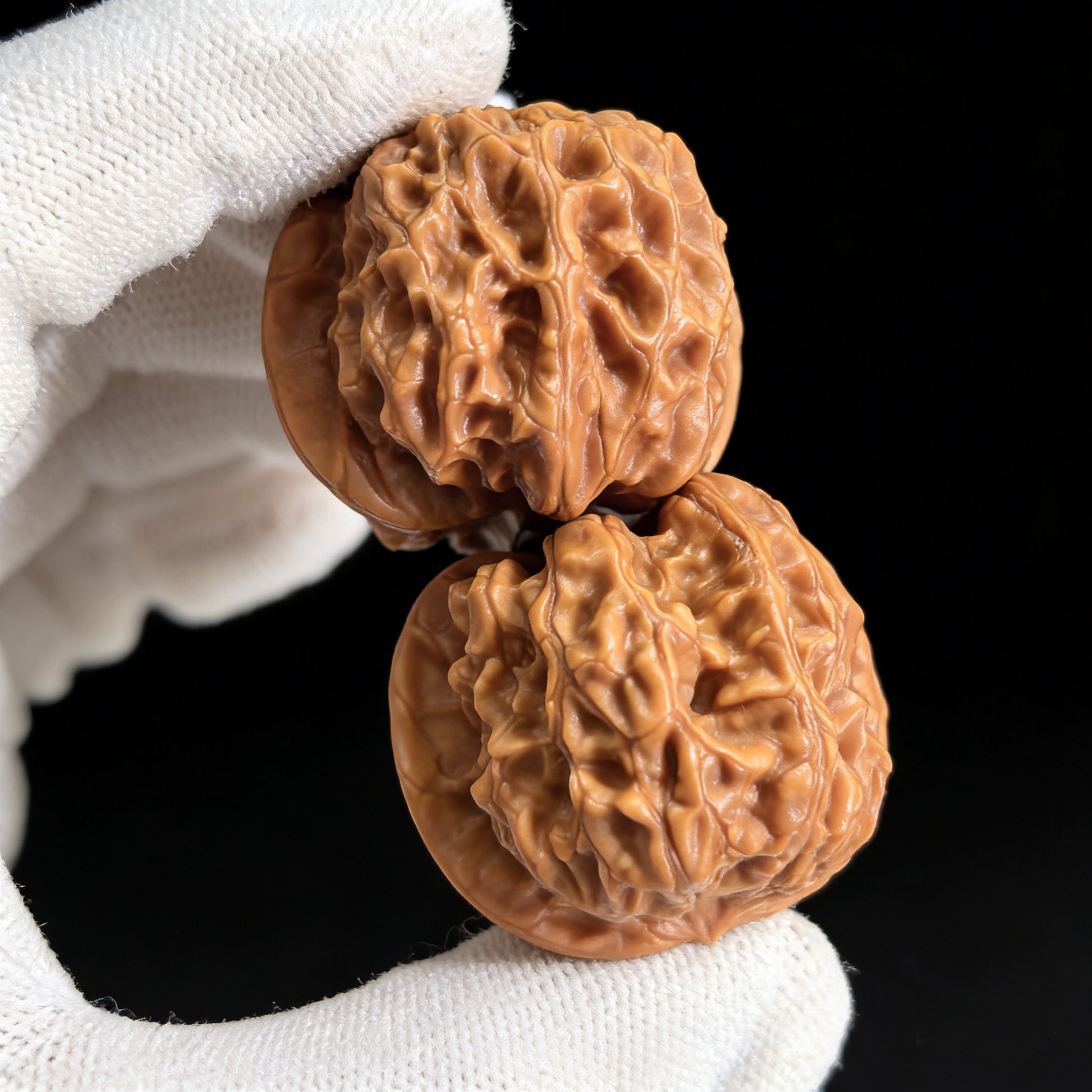 Pair of Xinglong Shaozi walnut hand exercisers with 35mm diameter from ThePatinaProject, showing smooth wooden surfaces and ergonomic design.
